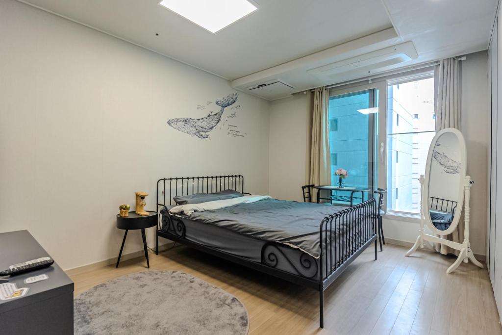 une chambre avec un lit et une fenêtre dans l'établissement 광안리해수욕장 30초# 무료주차# 해수욕장 뷰# 민락더마켓# 수변공원, à Busan