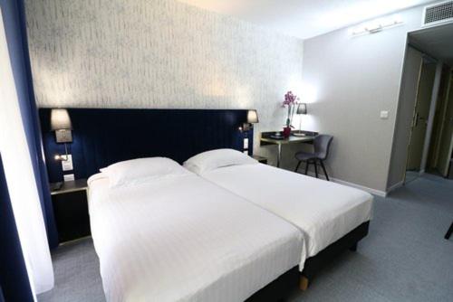 Postel nebo postele na pokoji v ubytování Hôtel Napoléon