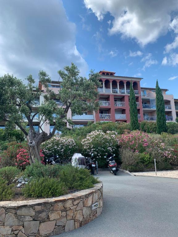 un bâtiment avec un arbre et des fleurs dans un parc dans l'établissement Studio vue mer, à Roquebrune-sur Argens