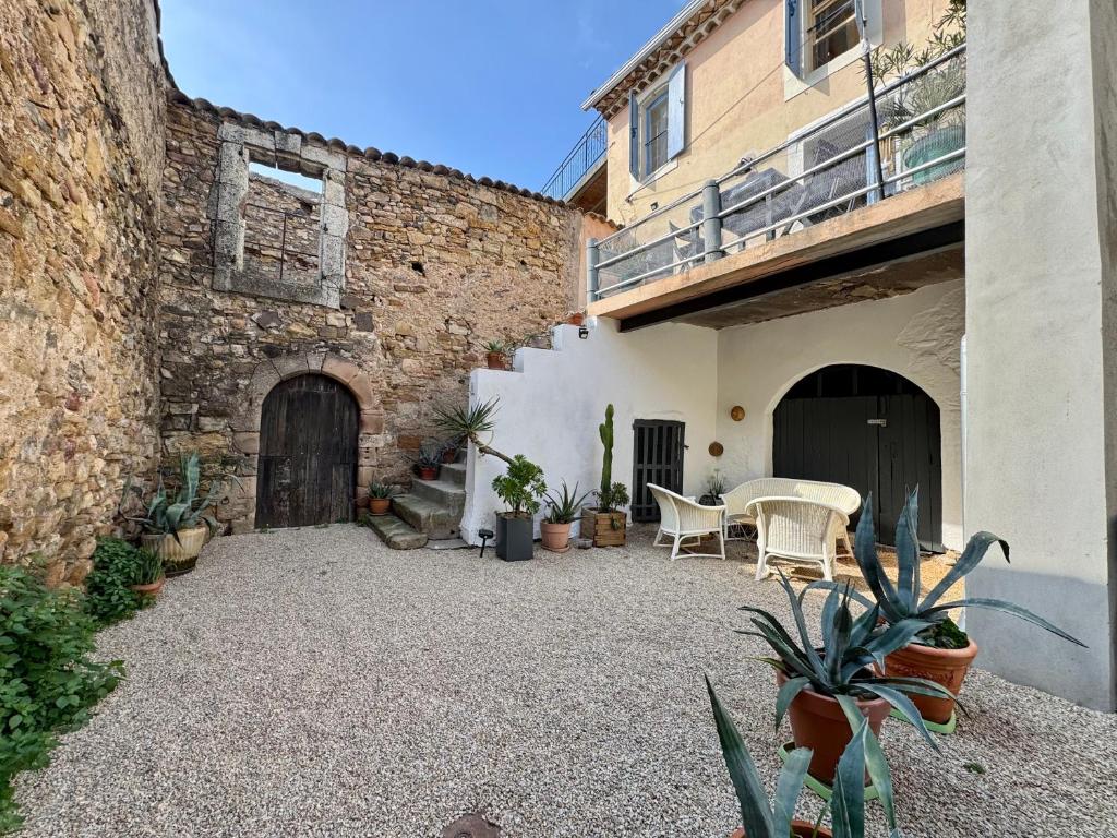 un patio avec une table et des chaises à côté d'un bâtiment dans l'établissement Maison de vacance familiale Tomlina, Neffies, à Néffiès