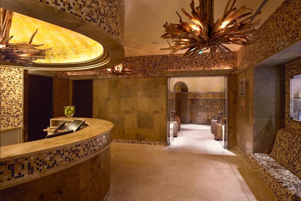 a lobby of a restaurant with a counter and chandeliers at Grande Real Villa Itália Hotel & Spa in Cascais
