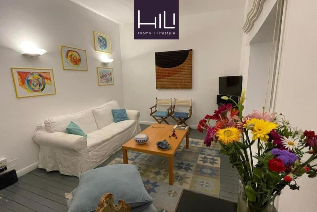 a living room with a couch and a table with flowers at Vicolo San Trifone by Hili in Rome