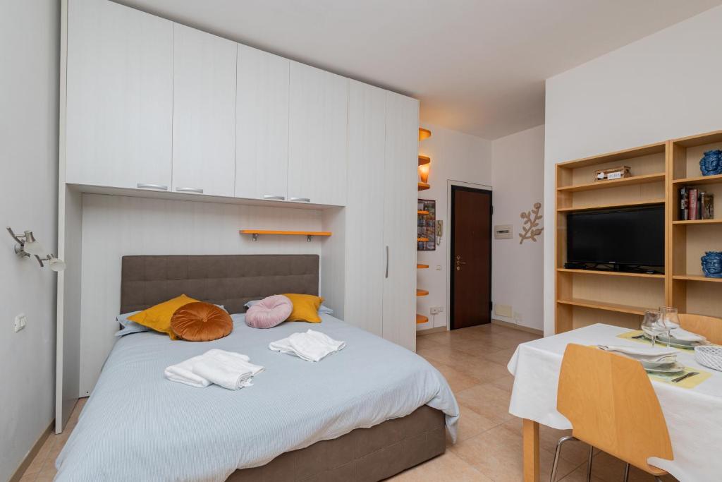 a bedroom with a bed with white cabinets and two chairs at Duomo di Pavia - Comodo bilocale in centro città in Pavia
