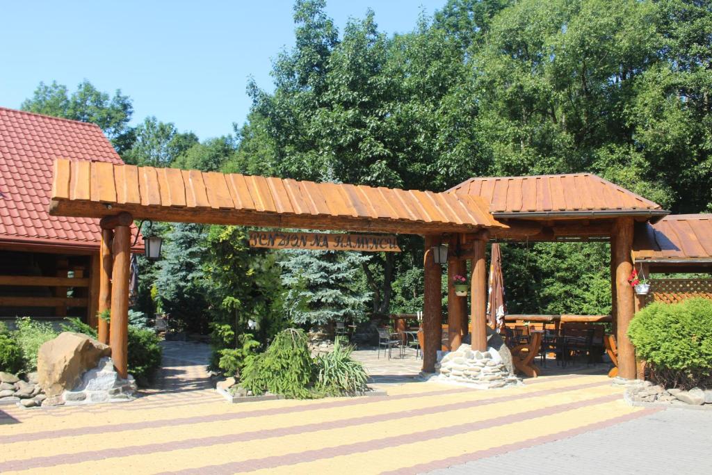 a wooden pergola in a park with trees at Penzion Na Kamyncu in Jablunkov