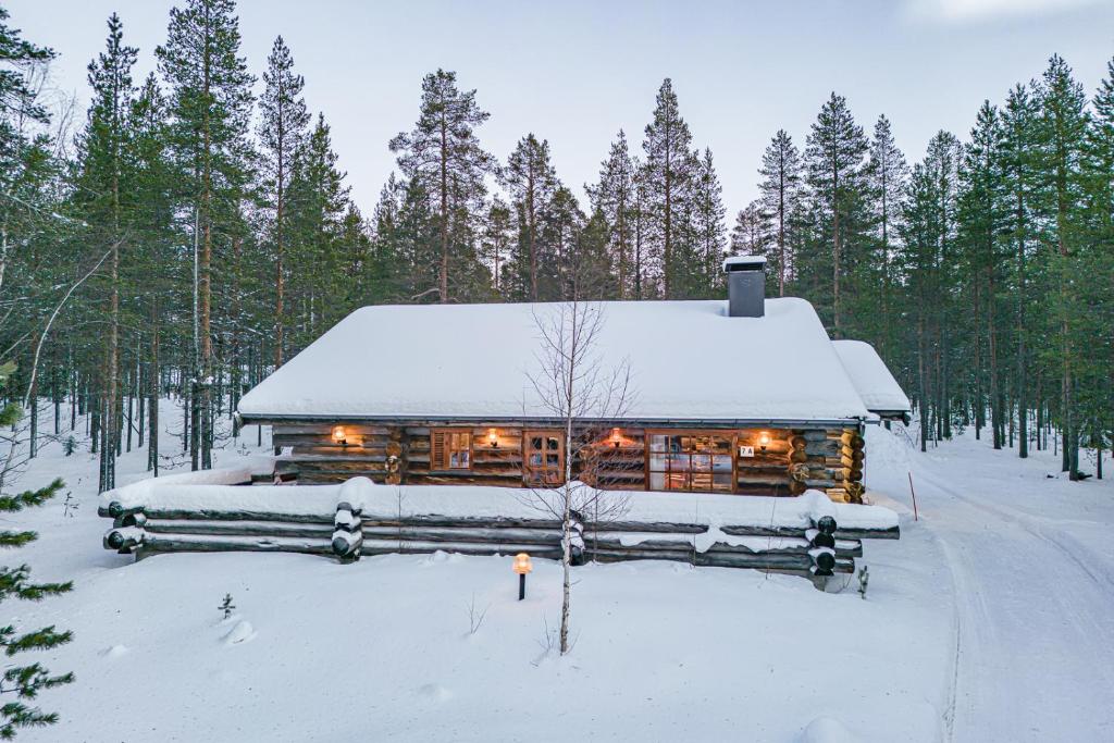 eine Blockhütte im Wald im Schnee in der Unterkunft Charming Cottage Levi in Levi
