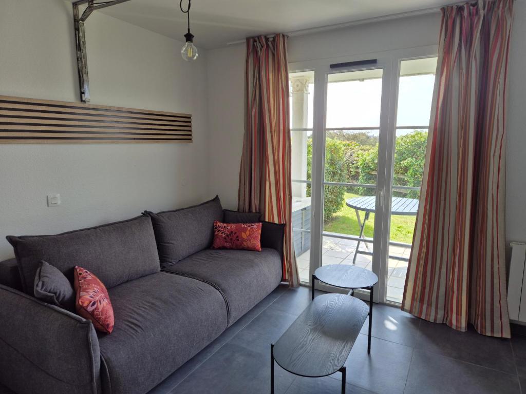 un salon avec un canapé et une table dans l'établissement Ref 066 A louer pour les vacances T3 pour 4 personnes avec piscine, à Arzon