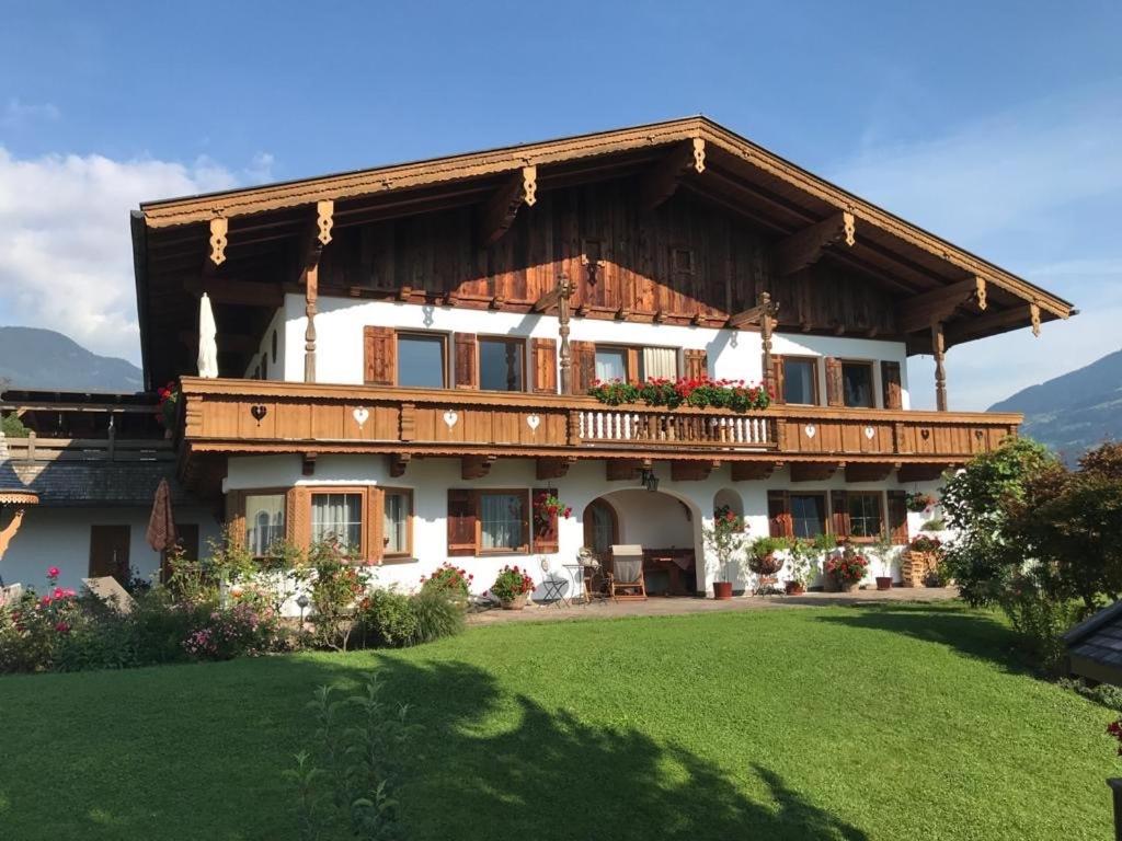 a large house with a wooden roof at Appartements Pfister in Fügen