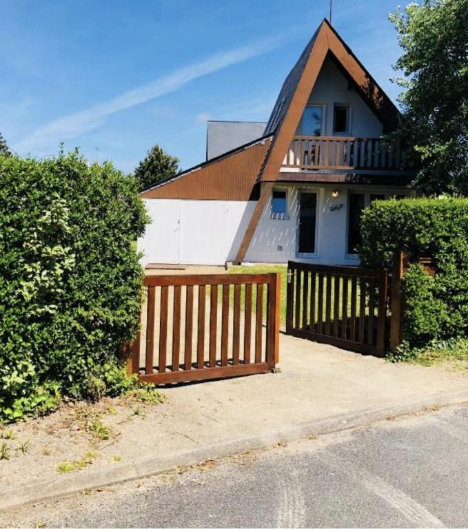 une maison avec une clôture en bois devant elle dans l'établissement Maison bord de mer la Turballe, à La Turballe
