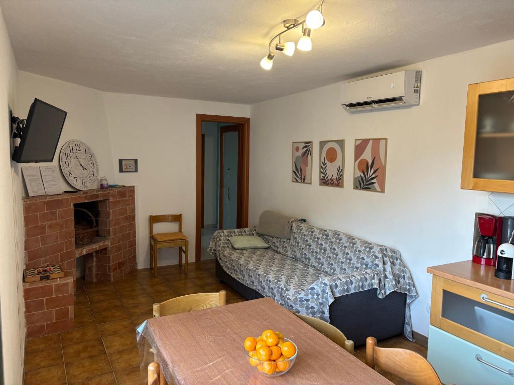 ein Wohnzimmer mit einem Bett und einem Tisch in der Unterkunft La casa degli Ulivi in Camporosso