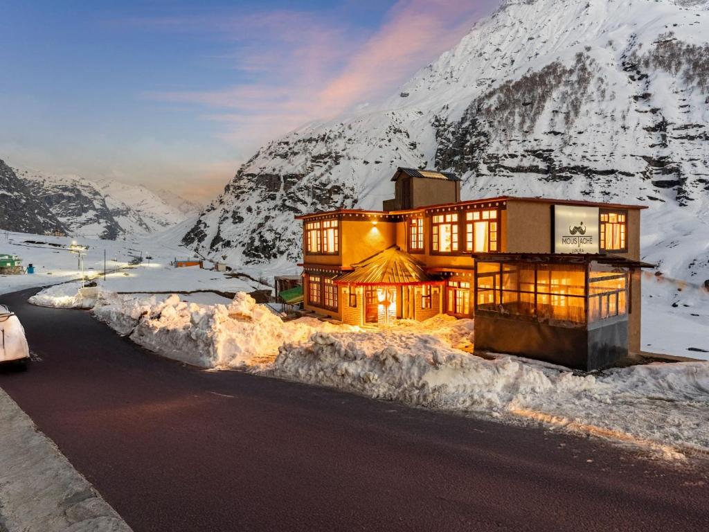 ein Haus an der Seite eines Berges im Schnee in der Unterkunft Moustache Koksar Luxuria, Sissu in Khoksar