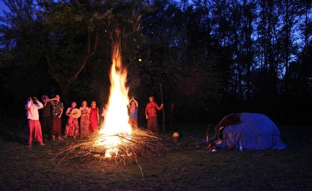 Un gruppo di persone intorno a un grande falò di Sacred Valley Mystic Tribe a Písac