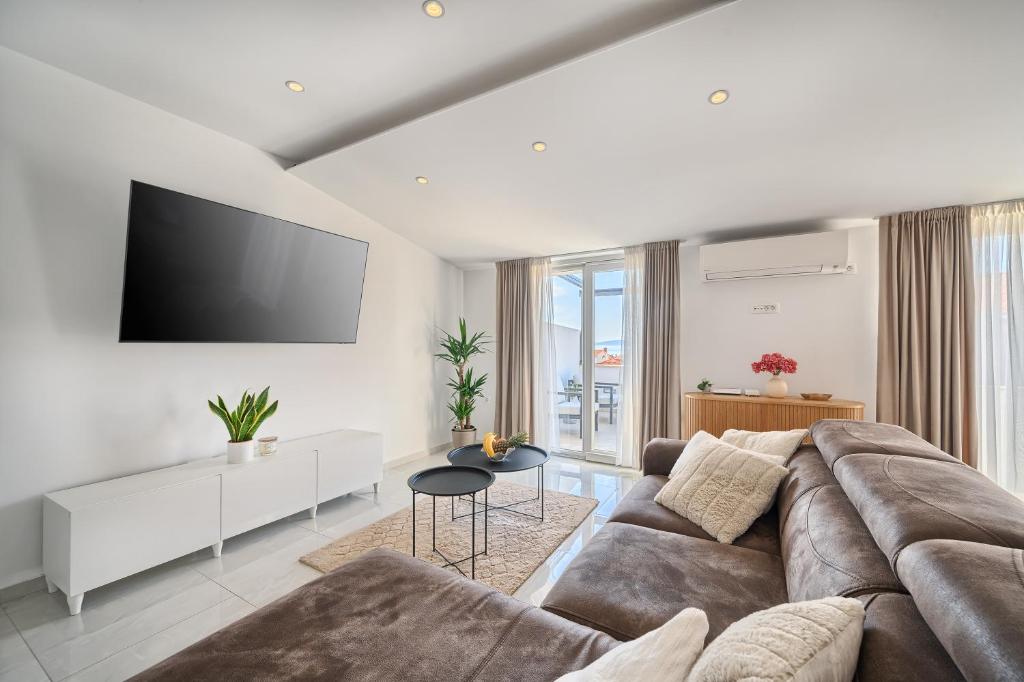 a living room with a couch and a flat screen tv at 3rd Floor Apartman in Kaštela