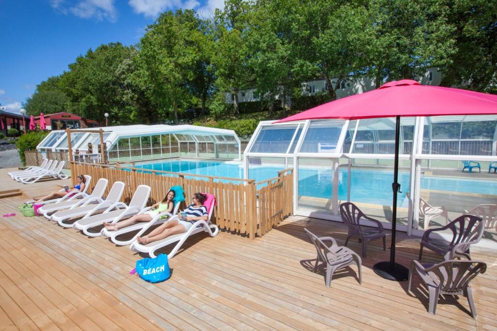 - un groupe de personnes assis sur des chaises à côté d'une piscine dans l'établissement Camping Le Paradis - Maeva, à Talmont-Saint-Hilaire