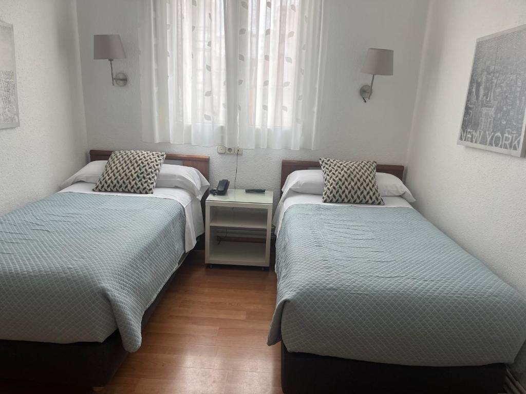 A bed or beds in a room at Pensión Lizaso