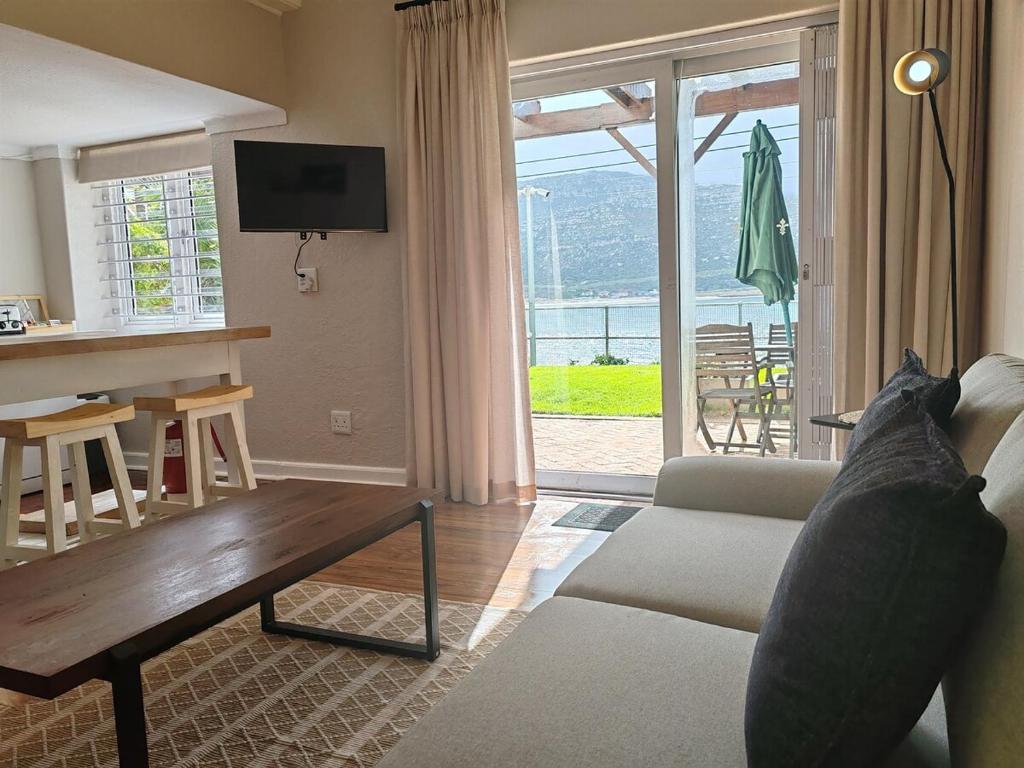 a living room with a couch and a table at Sunny Cove Stays in Fish Hoek
