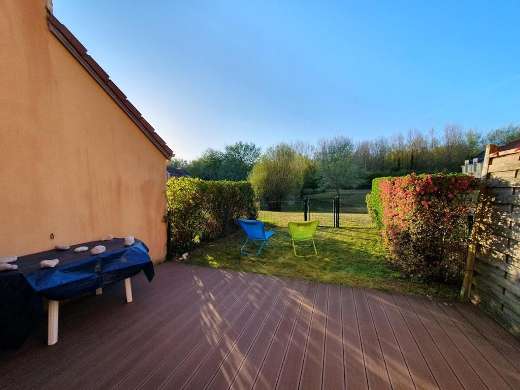 a patio with two chairs and a ping pong table at Maison rêv'etang, Cayeux-sur-Mer, Baie de somme in Cayeux-sur-Mer