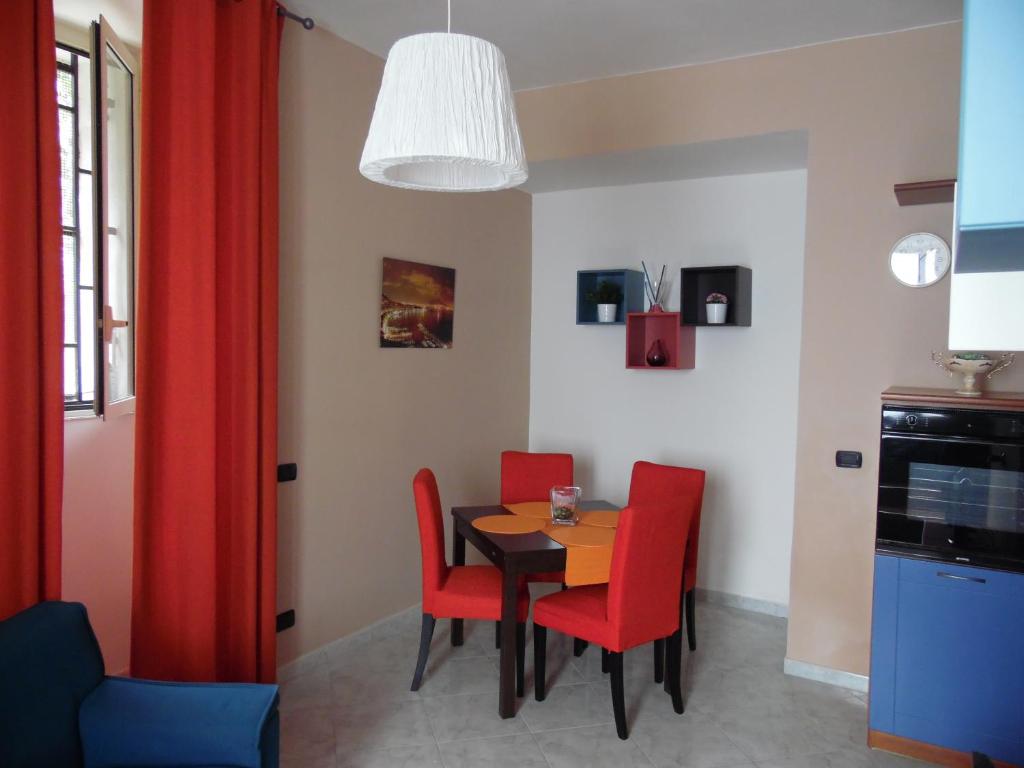 una sala da pranzo con tavolo e sedie rosse di Home Sweet Home a Napoli