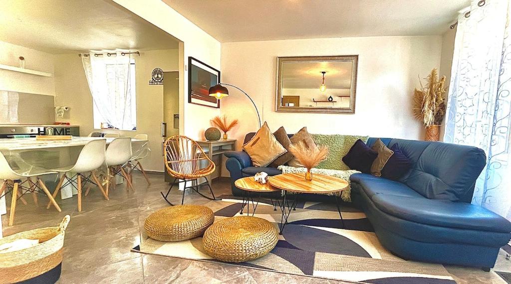 un salon avec un canapé bleu et une table dans l'établissement La Villa Scarlett, à Paluel