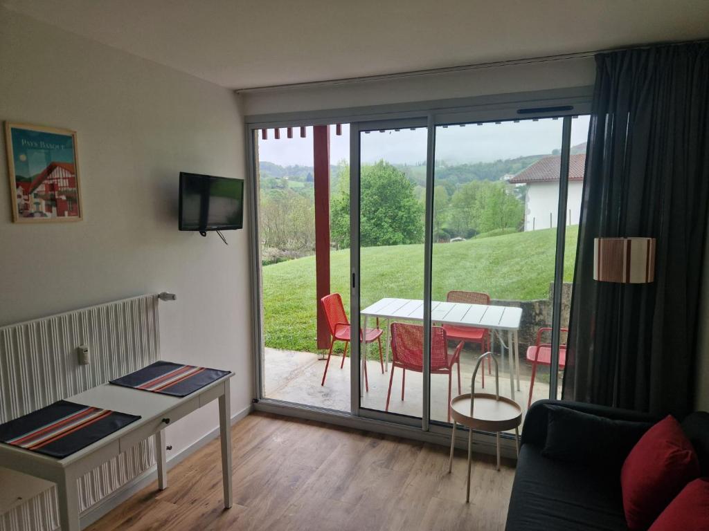 - un salon avec vue sur une table et des chaises dans l'établissement BAYONNE Piscine Vue Montagnes, à Souraïde