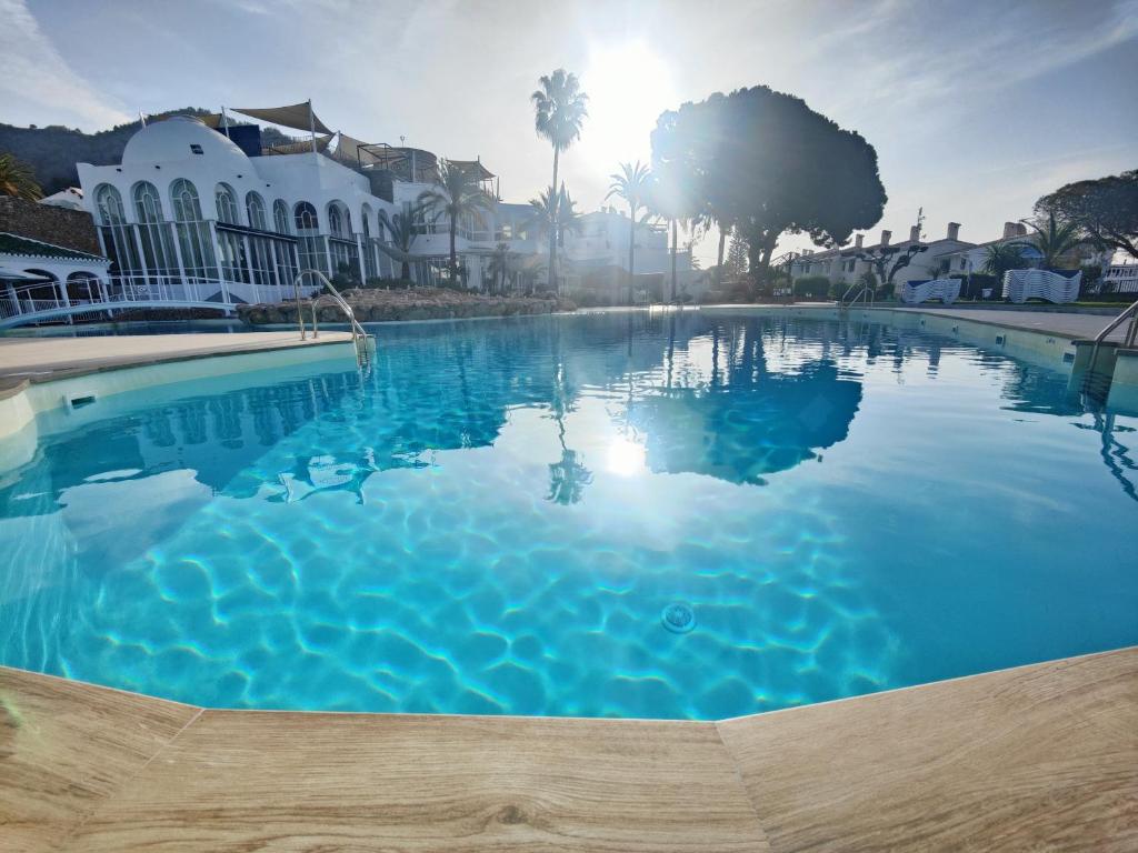 a large pool of blue water in front of a house at AP417 Los Mandarinos in El Molino