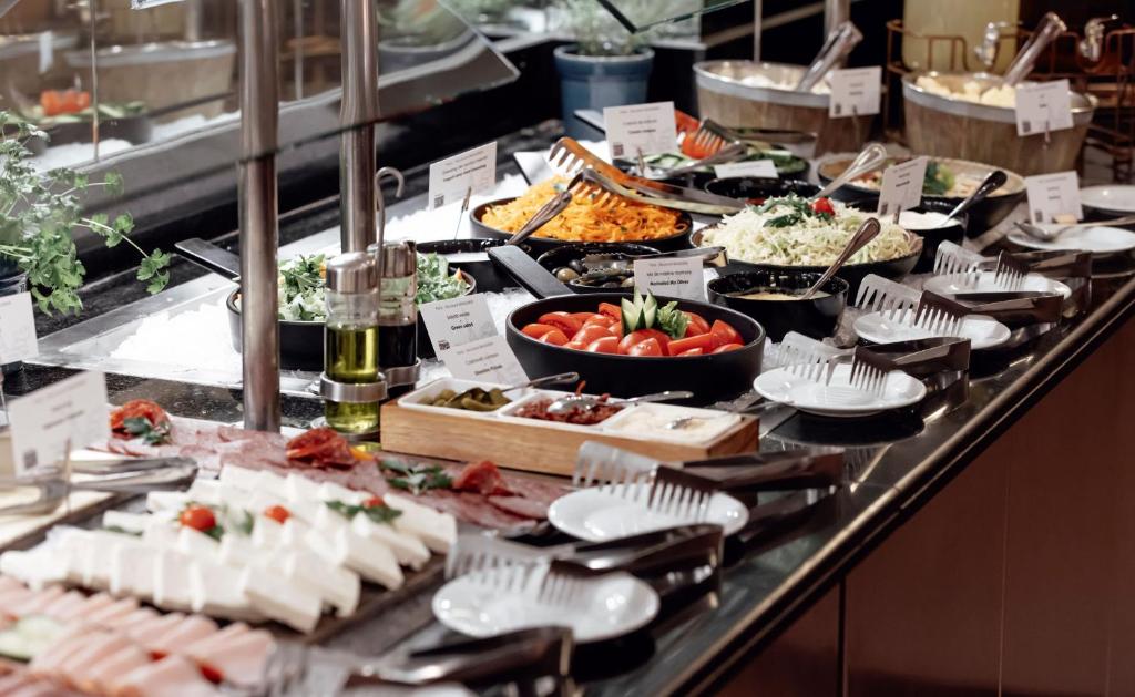a buffet line with many different types of food at Pullman Bucharest World Trade Center in Bucharest