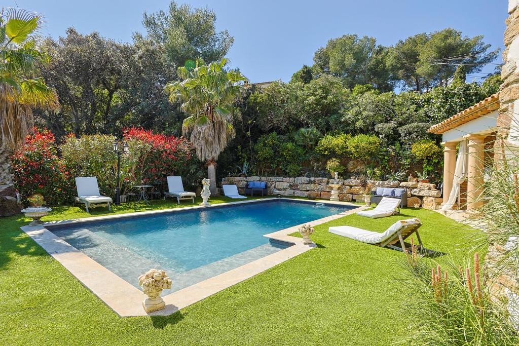 - une piscine dans une cour avec de l'herbe et des arbres dans l'établissement Val de Mer - Piscine et Grand Jardin, à La Croix-Valmer