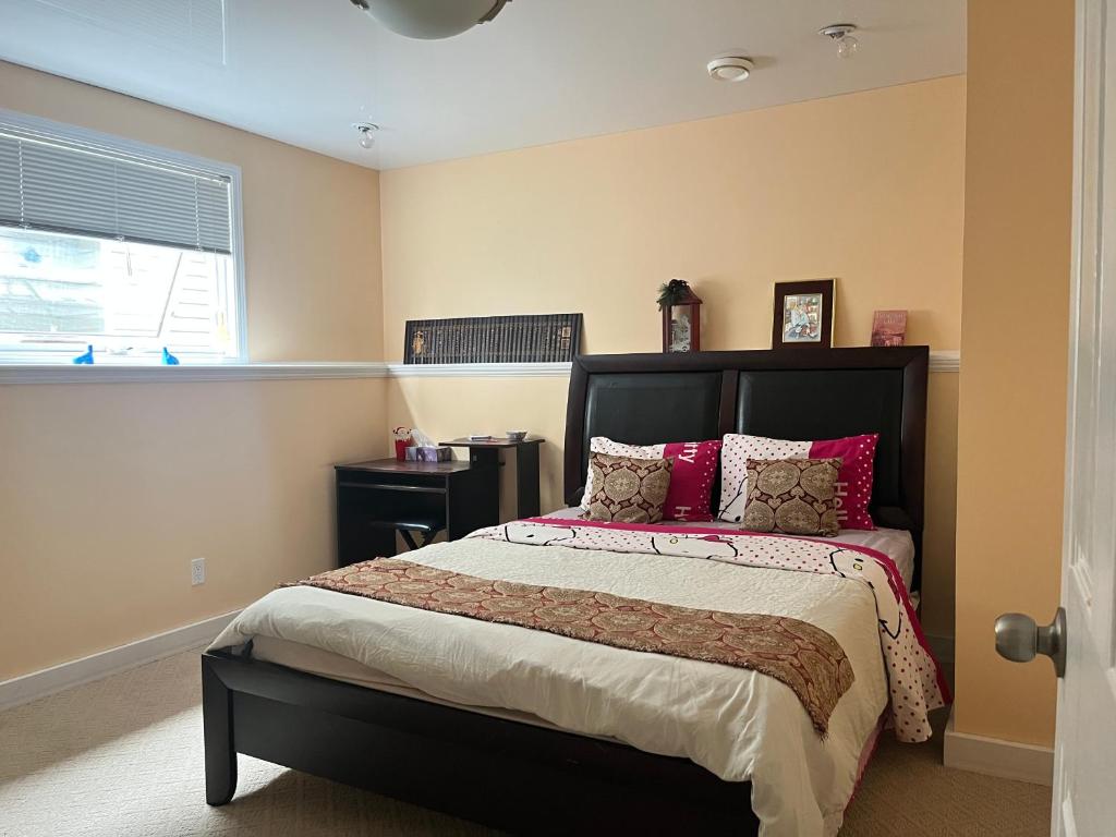 a bedroom with a large bed with red pillows at citadle hill house! in Calgary