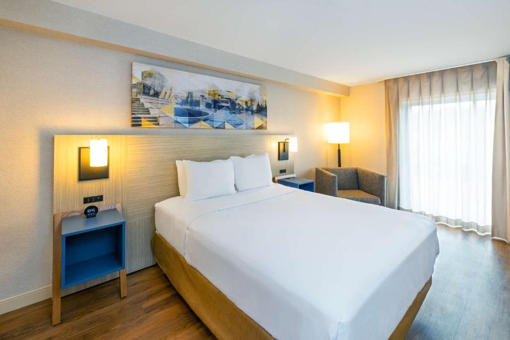 a hotel room with a large white bed and a window at Comfort Inn in Amherst