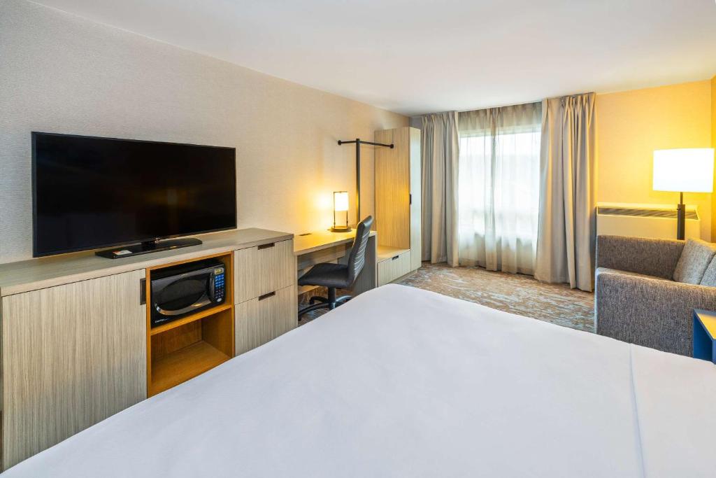 a hotel room with a bed and a flat screen tv at Comfort Inn in Amherst