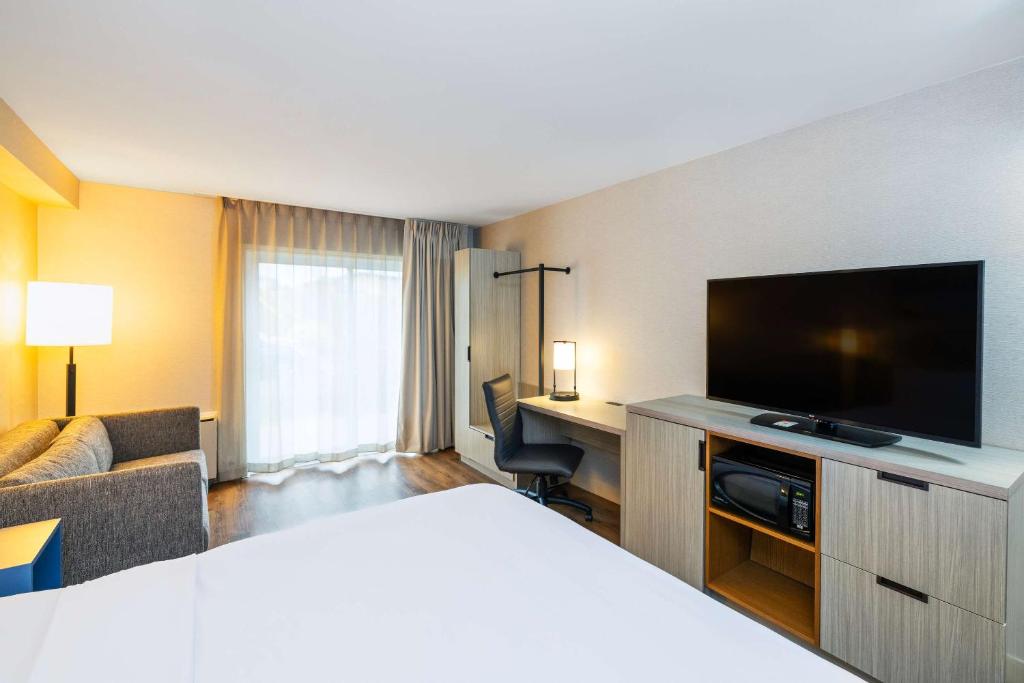 a hotel room with a bed and a flat screen tv at Comfort Inn in Amherst