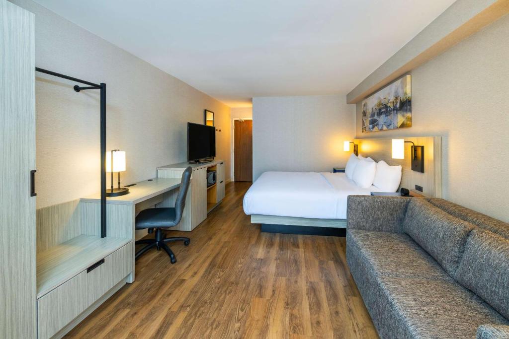 a hotel room with a bed and a desk and a couch at Comfort Inn in Amherst