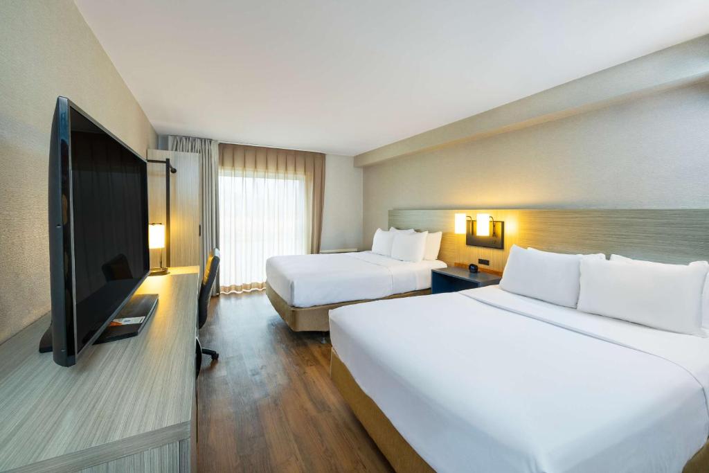 a hotel room with two beds and a flat screen tv at Comfort Inn in Amherst