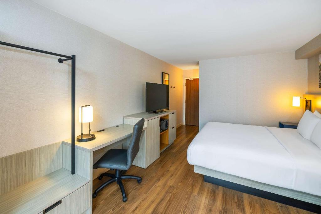 a hotel room with a bed and a desk with a computer at Comfort Inn in Amherst