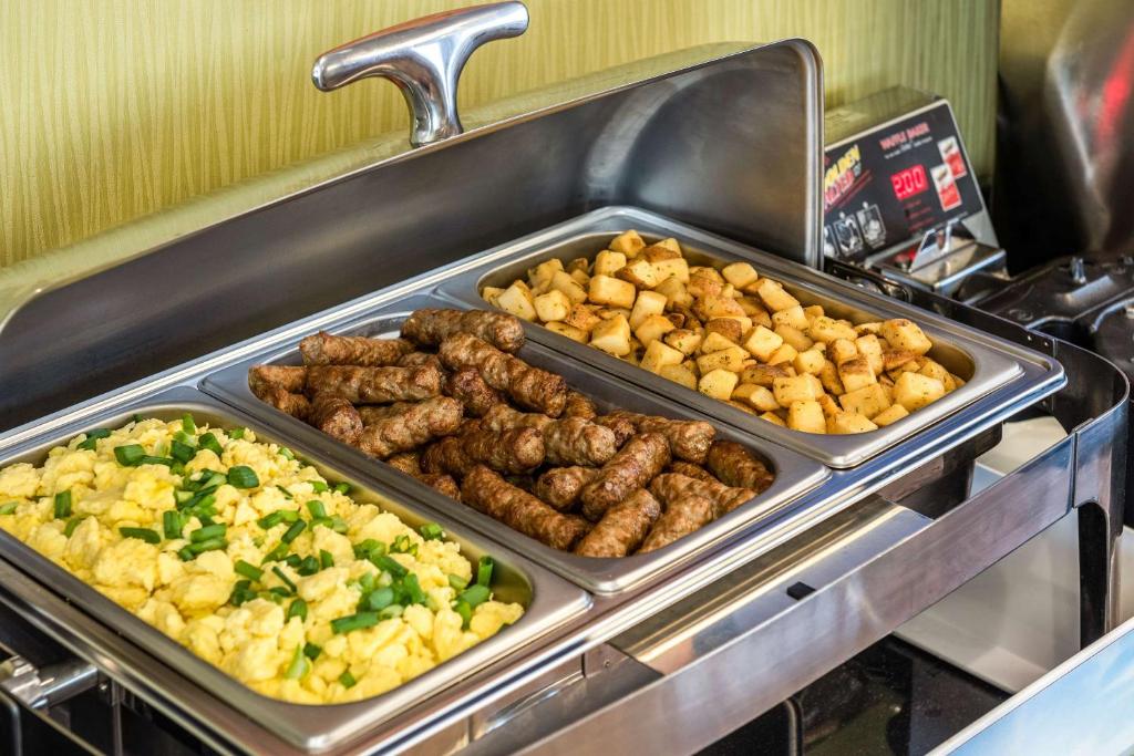 a buffet with several trays of meat and vegetables at Comfort Inn in Amherst