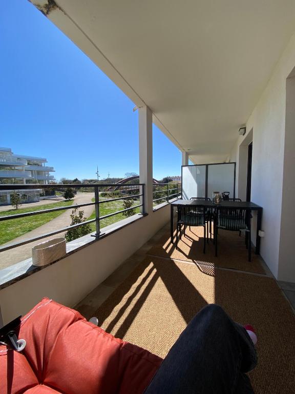 une personne allongée sur un canapé dans un salon avec vue dans l'établissement Appartement à 15 min à pied du vieux port, à La Rochelle