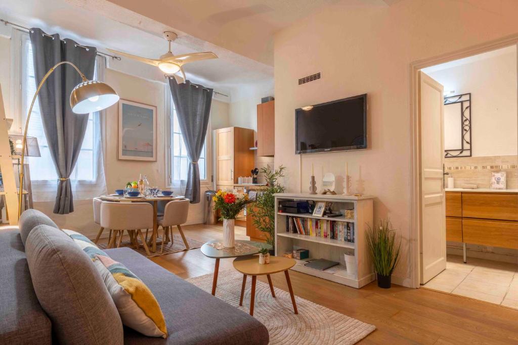 un salon avec un canapé et une table dans l'établissement Charming flat, fully equipped, beach only 300m - LA LOGE, à Nice