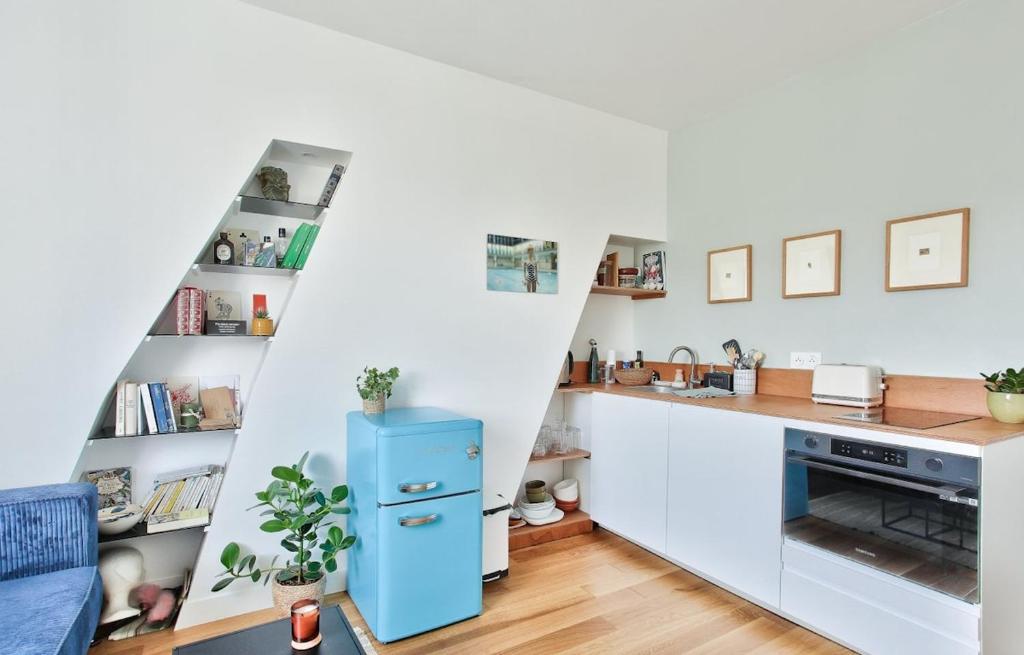 - une cuisine avec un réfrigérateur bleu dans la chambre dans l'établissement Appart central vue tour-Eiffel, à Paris