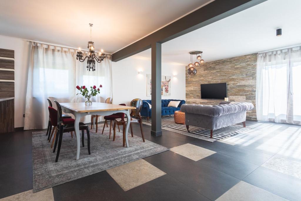 a dining room and living room with a table and a couch at Villa Vitovlje in Vitovlje