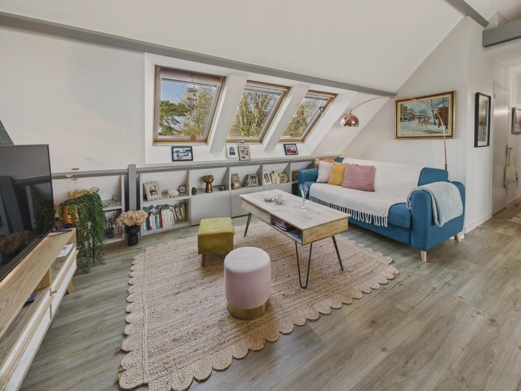 a living room with a couch and a table at Bel appartement avec balcon pour 3 personnes in Fouesnant