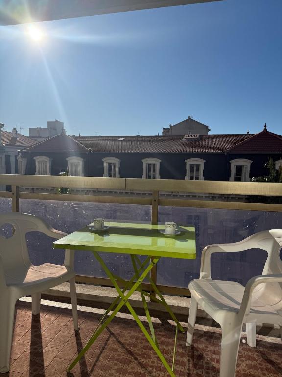 d'une table verte et de deux chaises sur le balcon. dans l'établissement Central location, terrace, 2 bedrooms, à Cannes