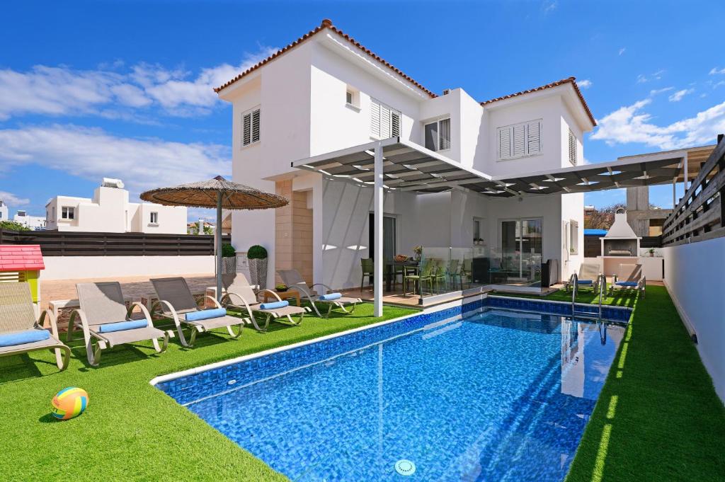 a swimming pool in the backyard of a house at Villa White Star - 100m from Serena Beach in Protaras