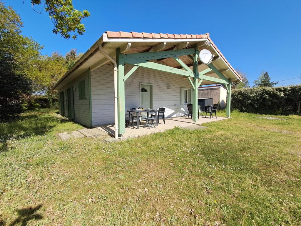 - un pavillon avec une table et des chaises dans la cour dans l'établissement La Maison des Coquilles, à Lanton