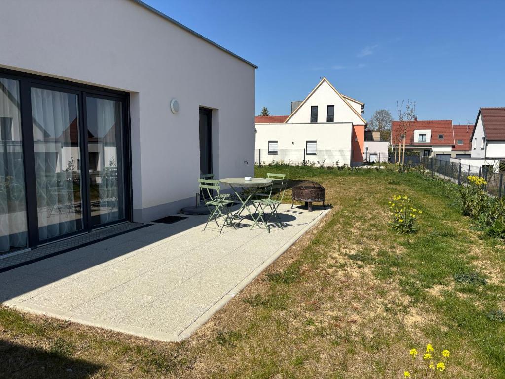 une terrasse avec une table et des chaises à côté d'une maison dans l'établissement L'Isenciel - Maison de plain pied avec Jardin et Parking, à Rouffach