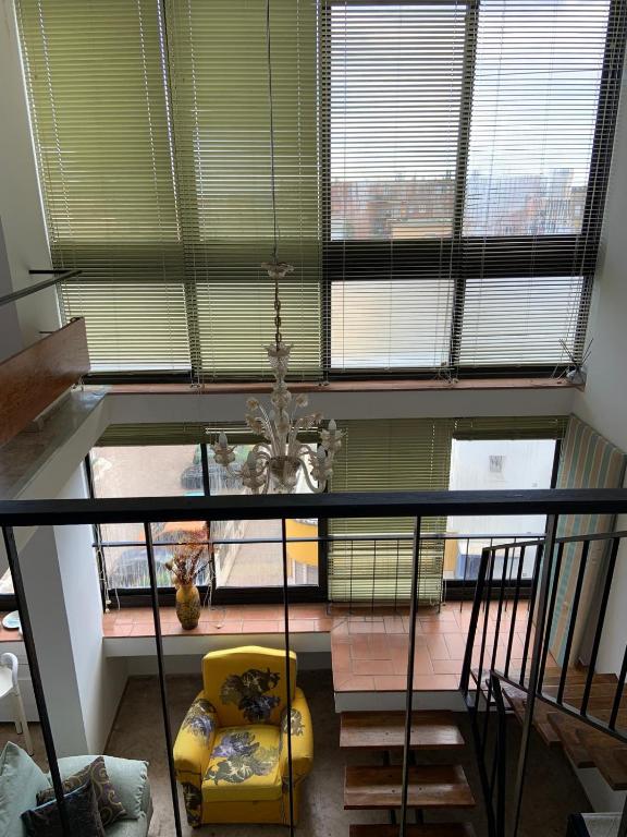 a living room with a yellow chair and a large window at LightHouse in Albissola Marina