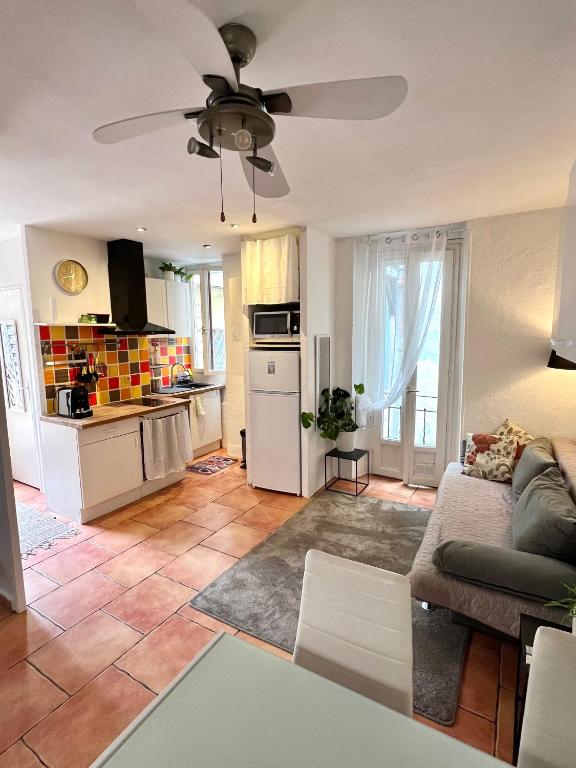un salon avec un canapé et un ventilateur de plafond dans l'établissement Appartement à Nice Acropolis avec terrasse, à Nice
