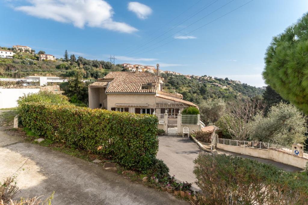 une maison avec une colline en arrière-plan dans l'établissement Havre de paix - Wifi, AC, parking, 4 pers, à Nice