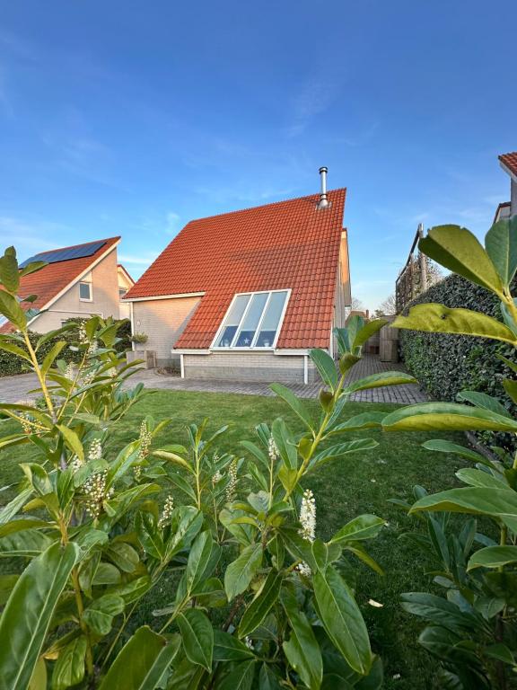 ein Haus mit einem roten Dach und einem Hof in der Unterkunft Ferienhaus im Villenpark Scharendijke in Scharendijke