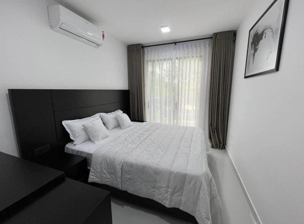 ein Schlafzimmer mit einem weißen Bett und einem Fenster in der Unterkunft The Divines Edge in Hikkaduwa