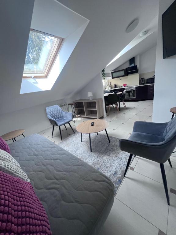 a living room with a bed and chairs and a table at Apartamenty Pokoje Willa Bielany in Warsaw