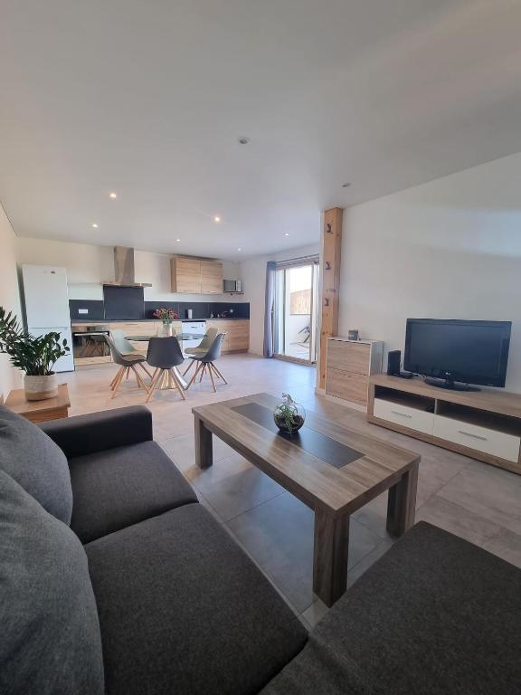 un salon avec un canapé et une table basse dans l'établissement Le Jura entre Annecy et Genève, à Feigères